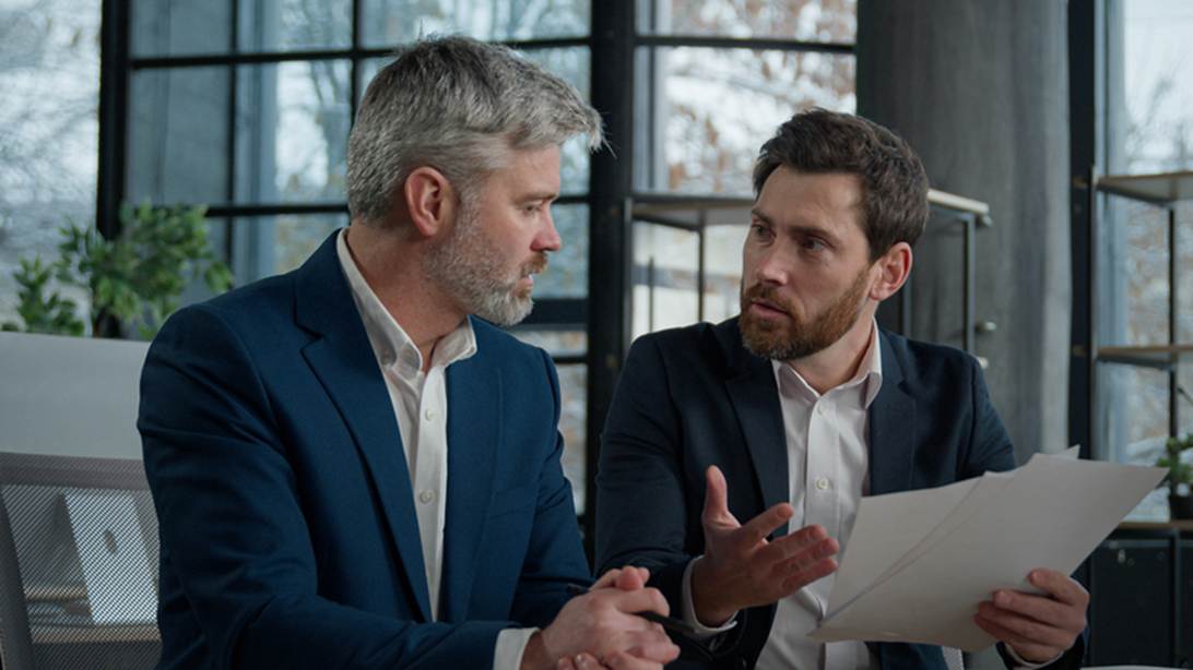 Two men in suits talking to each other
AI-generated content may be incorrect.